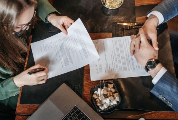 Business professional reviewing and signing a technology contract - Marinum Consulting Business professional reviewing and signing a technology contract